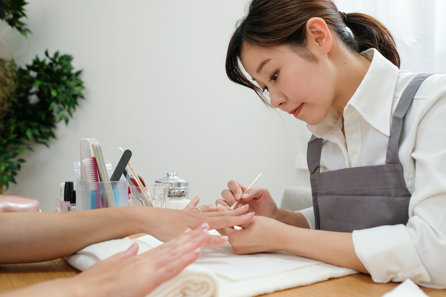 Nail stylist decorating fingernail