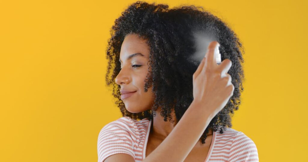 hair styling hairspray_young woman sprays hair products