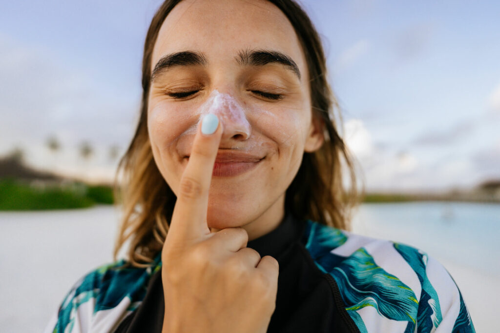 woman putting sunscreen on nose